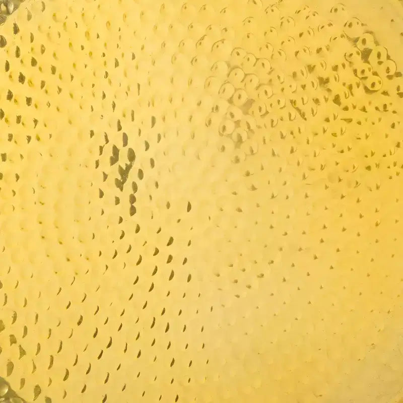 Tavolino rotondo d'appoggio, piano martellato color oro champagne con base in vetro verde